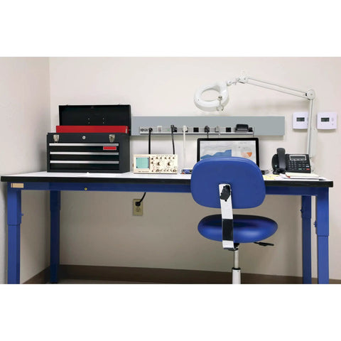 8-Outlet Surge Protector Power Strip With 6-Foot Cord, Metal Housing, mounted on a lab workbench alongside tools and equipment.
