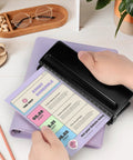 Rugged 6 Hole Paper Puncher With Adjustable Ring Spacing For A5, A6, A7 Formats, in use on a planner page, black