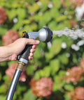 Hand using Small Metal Garden Hose Nozzle With Seven Spray Patterns, Easy Grip Handle For Smaller Hands, in garden