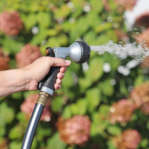 Hand using Small Metal Garden Hose Nozzle With Seven Spray Patterns, Easy Grip Handle For Smaller Hands, in garden