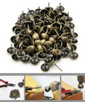 Top Shelf 100 Piece Set Of Antique Bronze Upholstery Nails And Decorative Furniture Tacks in a pile, ideal for DIY projects.