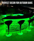 Outdoor 100Ft IP68 Waterproof LED Strip Lights illuminating a stone bar setup with green lighting at night