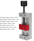 Compact Aluminum Mini Bench Vise For Woodworking Hobbyists, A Handy Little Table Clamp With 50mm Jaw Range, 123mm Overall Length, 20mm Mount Hole Distance, Ideal For Engraving, Drilling, And Small Repairs. Silver mini bench vise with red jaw block and black screw handle.