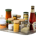 360 Degree Spinning Clear Lazy Susan Turntable For Fridge And Pantry With Tough As Nails Plastic Organization Tray and Smooth Ride Spin Plate, filled with jars and condiments in a clear tray.