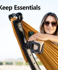 Close-up of Setup in 3 Seconds Adjustable Portable Aluminum Hammock Stand showing accessory holder with a person using it outdoors.