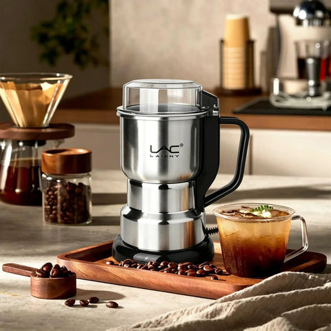 Top Shelf Electric Coffee Grinder And Spice Mill Featuring A Hella Quick 150 Watt Motor Plus Razor Sharp Stainless Steel Blades For Roasted Beans Fresh Herbs Whole Spices And Nuts Boss Cleaning Kit Included on a wooden tray with coffee beans and a drink.