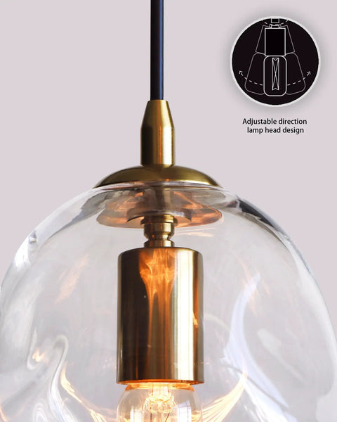 Close-up of Dope Clear Art Glass Pendant Lights 2 Pack for Kitchen Island showing brass hardware and adjustable lamp head design.
