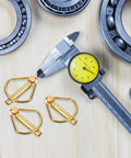 Get These Heavy Duty Linch Pins With Ring For Tractor And Trailer! Made Of Tough Carbon Steel, These Precision Quick Release Shaft Locking Fasteners Are Total Game Changers For Ag And Industrial Use. Display of gold carbon steel linch pins beside caliper and bearing.