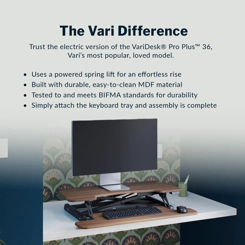 Vari Pro Plus 36 Electric Standing Desk Converter In Stylish Walnut Finish with monitor and keyboard on top, showcasing electric lift features.