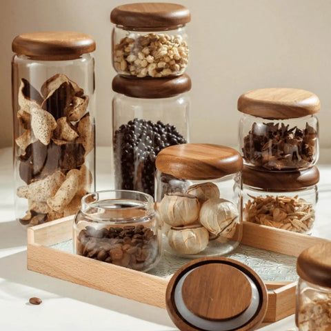 Four Piece Glass Storage Jars With Airtight Wooden Lids Wide Mouth Canister Set filled with snacks and coffee on a wooden tray.