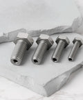 Pro Grade 4 Piece Heavy Duty Stainless Steel Busted Stud Drill Guide Kit M6 M8 M10 M12 showing four stainless bolts on a stone surface.