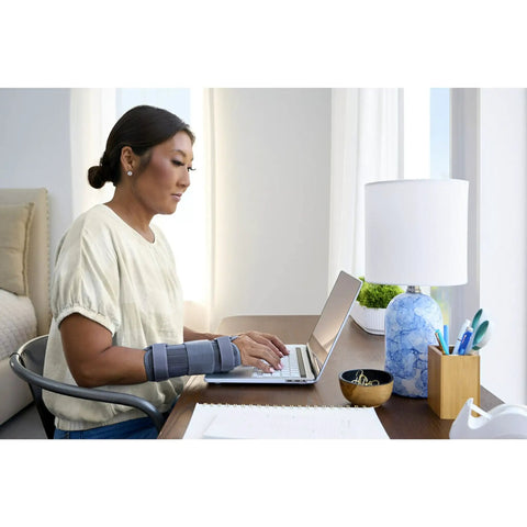Woman using laptop wearing Deluxe Wrist Stabilizer For Right Hand, Adjustable Straps, Breathable All Day Comfort, Small to Medium
