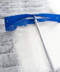 Heavy Duty Extendable Roof Snow Rake With Gliding Rubber Wheels And Lightweight Aluminum Handle clearing snow off a roof.