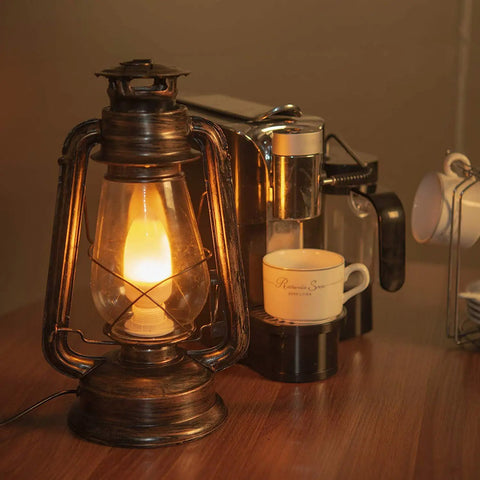 Pack Of 2 Vintage Rustic Lantern Lamps With Edison LED Bulbs, Bronze Rust Finish on a wooden table next to coffee machine.