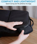 Person placing black Cord Organizer Travel Kit For Chargers And Cables, Slim Single Layer Tech Bag into a suitcase.