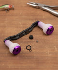Upgrade Your Gear With This Premium Carbon Fiber Fishing Reel Handle Assembly Featuring Ergonomic TPE Foam Knobs And Non Slip Design For Ultimate Balance And Smooth Cranking Action In Any Angling Adventure Out There Today. carbon fiber reel handle with purple foam knobs and hardware