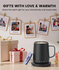 14 Oz Self Heating Coffee Mug With Quick Rechargeable Battery on a table near gift boxes and holiday decorations.