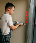 Professional Grade 200 Count Quarter Inch Thick Red Plastic Shims For No Sweat Tile Leveling And Reliable Door Window Gap Filling Designed To Keep Your Home Projects Looking Clean And Dead Nuts Straight Daily being used with caulking tool.