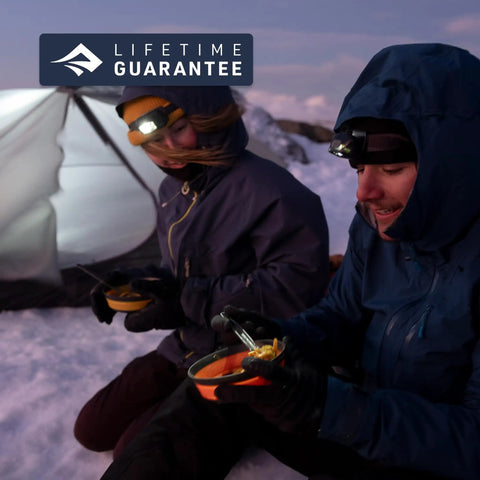 Campers eating with Frontier Ultralight Collapsible Bowl Large 30 Fl Oz Puffins Bill Orange Packable Camping Dish in snow.