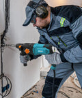 Man using One Inch SDS Plus Rotary Hammer Drill With Safety Clutch 7 Amp Corded 4 Function Variable Speed for drilling wall