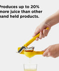 Hands using No Fuss Lemon Squeezer Citrus Juicer With Dual Gear Power Manual Hand Press pouring juice into glass.
