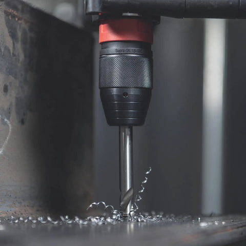 Close-up of 18V Cordless Driver Drill Kit Handles Heavy Demands With Two 18V 5.5Ah Batteries and drill bit in metalwork.