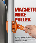 Hand using Powerful Magnetic Wire Puller for electrical wiring, guiding cable through wall with rare earth magnets and stainless steel leader.