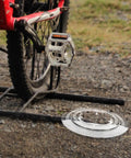 Chain Guard And Spoke Protector For Mountain And Road Bikes next to a bike on gravel path.