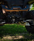 High Clearance Boxed Rear Radius Arms Beefed Up For Polaris RZR XP 900 And XP 4 900 2011 To 2014 Black Finish Heavy Duty Welded Strength Upgrade For Tough Trails And More Maneuverability. Rear view under UTV on trail