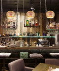 Set of 3 Modern Glass Pendant Lights With Colorful 3D Firework Design illuminating a stylish bar area.