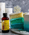 Bakery Emulsion Variety Pack For Cakes, Cookies And Desserts With Flavors Almond, Butter Vanilla, Lemon, Princess Cake And Cookie, Red Velvet, Strawberry Gluten Free And Keto Friendly, 4 Oz Bottles A Must Have For Home Bakers next to blue layered cake with snowflake topper