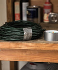 Duck Brand duct tape rolls; two colors (green coil, silver roll) on a wood workbench.