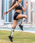 Woman running outdoors wearing Top Tier Gear Chip Industrial Socks With 15-20mmHg Graduated Compression For Calf Support.