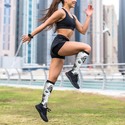 Woman running outdoors wearing Top Tier Gear Chip Industrial Socks With 15-20mmHg Graduated Compression For Calf Support.