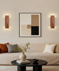 Feasey Set of 2 Walnut Wood Wall Sconce, Vintage Wall Mounted Light Fixture illuminating a modern living room with artwork.