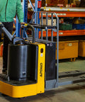 Heavy Duty Electric Pallet Jack Rider Packs Killer Six Thousand Six Hundred Pound Grip And Rock Solid Stand On Base With A Zippy Two Point Two Kilowatt Motor Plus Long Lasting Twenty Four Volt Battery For Zero Stress Warehouse Hauling And Smooth Floor in use on warehouse floor.