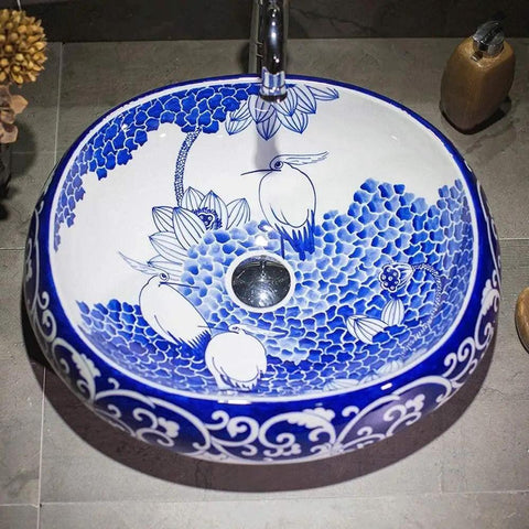 Slick Oval Vessel Sink For Bathroom Vanity Top Notch Premium Porcelain Countertop Wash Basin Featuring Hand Painted Lotus Bird Motif And Smooth High Gloss Finish, oval sink with blue floral design.