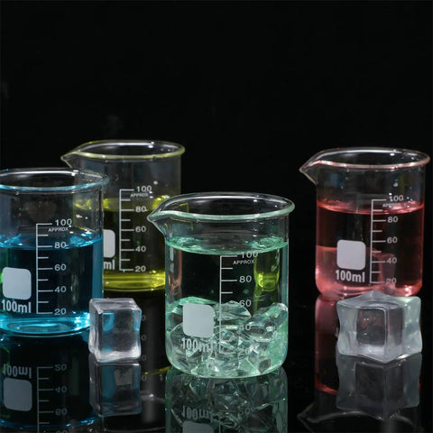 Four colored 100 ml glass beakers filled with liquid on black surface, part of the Twenty Pack 100 Milliliters Glass Beakers Set, Heavy Duty Borosilicate Lab Beakers With Printed Measurements, Bulk Quantity For Lab Or Classroom Or Home Science Projects.