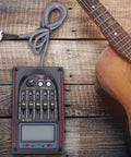 Five Band Acoustic Guitar Preamp With LCD Display Piezo Pickup LC-5 Equalizer Tuner And Mic Input next to guitar on wooden surface