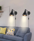 Set Of 2 Black Plug In Wall Sconces Industrial Style With On Off Cord Switch illuminating a cozy living room above a sofa.