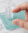 Clear PVC Shower Door Washer Replacement Kit 100 Pack Round Antiscratch Glass Protectors For Handles And Towel Bars Perfect For Glass Door Repair And Towel Bar Replacement Keeps Showers Looking Slick And Leak Free. clear round washer held by hand