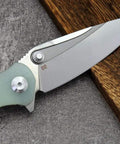 Close-up of Fast Opening Ball Bearing Folding Knife with D2 Steel Blade and Jade G10 Handle, for tactical and outdoor use.