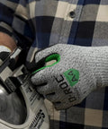 Close-up of D Roc ANSI A4 Reinforced Thumb NitriX Palm Work Gloves in use, size 9 Large, handling metal near machinery.