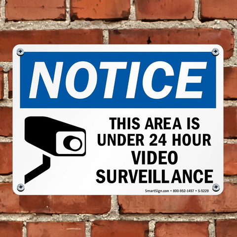 24 Hour Video Surveillance Security Camera Sign 10 By 14 Inch Heavy Duty Plastic Outdoor Notice Plaque mounted on brick wall.