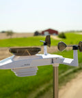 Optimus Weather Station With WiFi HD Display Solar Power Pack Lightning Detection Indoor Outdoor Temperature And Humidity Wind Speed And Direction Rainfall Measurements For Hyperlocal Readings installed in a rural setting.