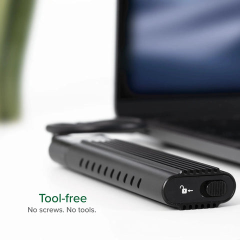 Close-up of tool-free M.2 NVMe SSD Enclosure USB-C 10Gbps rocket fast next to laptop, showcasing lock mechanism.