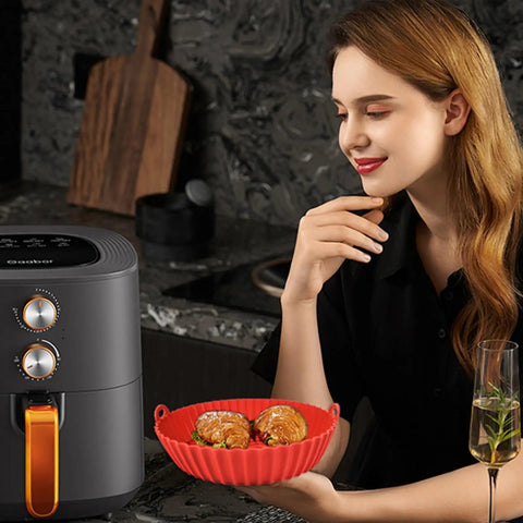 Person holding red Round 8 Inch Silicone Air Fryer Liners 2 Pack Red And Cyan Nonstick Reusable Heat Resistant Dishwasher Safe For 3 Qt to 6 Qt Fryers.