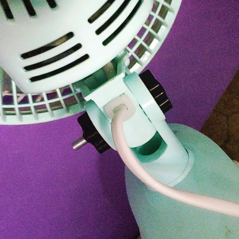 Close-up of a fan with a Star Shaped Knurled M8 Grippy Clamping Knobs Black Plastic Screw On Type visible near the base.