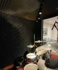 Twelve Pack High Density Pyramid Acoustic Foam Wall Panels With Strong Self Adhesive Backing Sound Proof Tile Blocks in a recording studio.