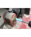 Using grease zerk cleaner kit for grease fittings with four color cleaners and one zerk fitting on machinery part.